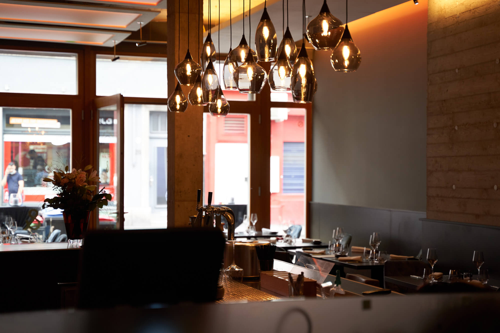 Innenansicht des dario& Restaurants mit gedeckten leeren Tischen. 