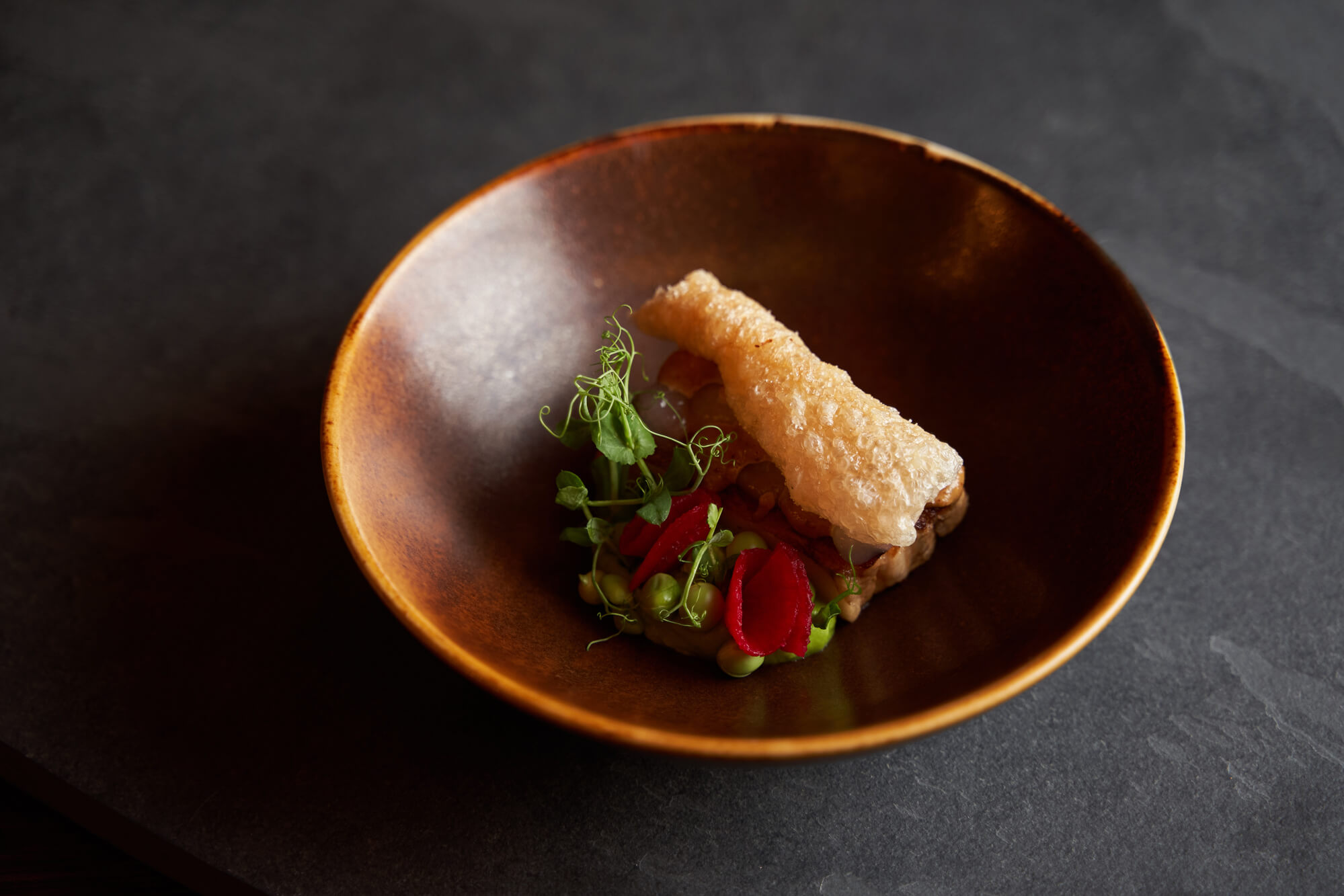 Schweinebauch angerichtet auf einem Teller.